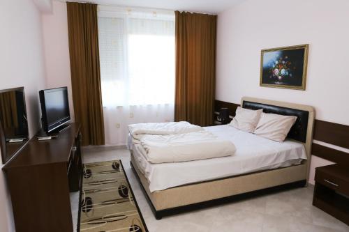 1 dormitorio con 1 cama y TV en Hotel Ida, en Kardzhali