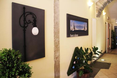 a hallway with plants and a picture on a wall at Albergo Al Viale in Trieste