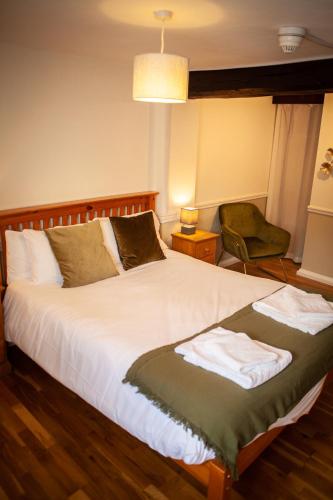a bedroom with a large bed and a chair at The Chagford Inn in Chagford