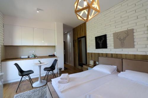 a bedroom with a bed and a table and chairs at All Seasons Residence in Zlatibor