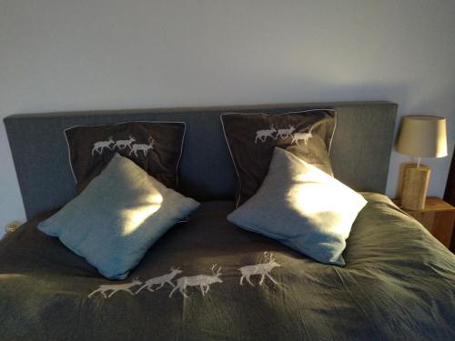 a bed with two pillows with deer on it at Les2sources Bike-B&B in Rochefort