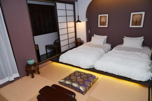two beds in a room with a room with a mirror at Asakusa New City Hotel in Tokyo