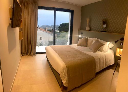 a bedroom with a large bed and a large window at VILLA BLANCHE in Cavalaire-sur-Mer