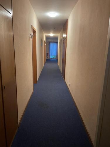 a long hallway with a blue carpet in a building at Lippborger-Hof in Lippetal
