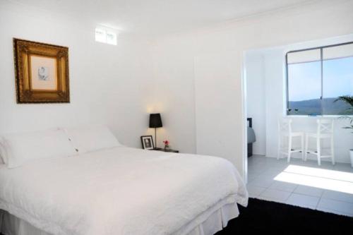 a white bedroom with a large bed and a window at Clouds Silver Lining in Beechmont