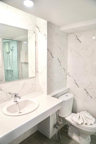 a white bathroom with a sink and a toilet at View Place Hotel & Residence in Bangkok