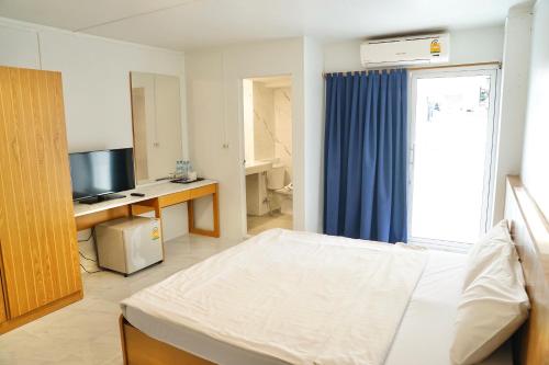 a bedroom with a bed and a tv and a window at View Place Hotel & Residence in Bangkok
