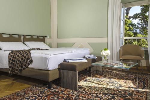 a bedroom with a bed and a glass table at Hotel Bogliaco in Gargnano