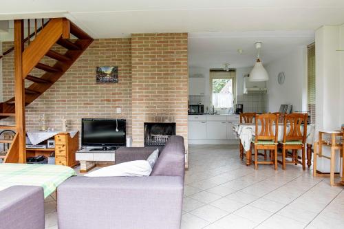 a living room and kitchen with a brick wall at Bungalow 40 op Recreatiepark De Wielen in Sint Maarten
