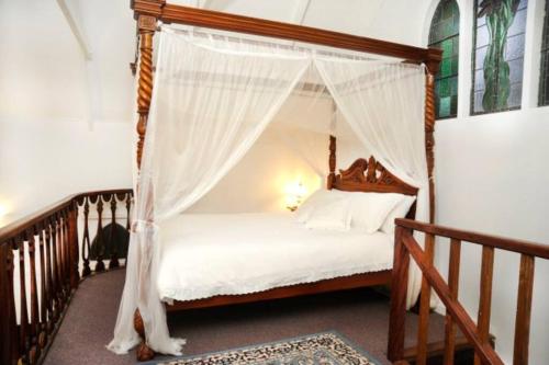 una cama con dosel en una habitación en Old Saint Johns Church, en Beechmont