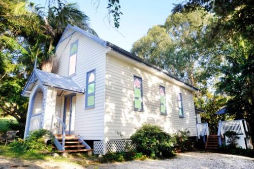 a small white house with colorful windows on it at Old Saint Johns Church in Beechmont