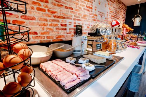 a buffet with meat and other foods on a counter at ibis Styles Lyon Bron Eurexpo in Bron