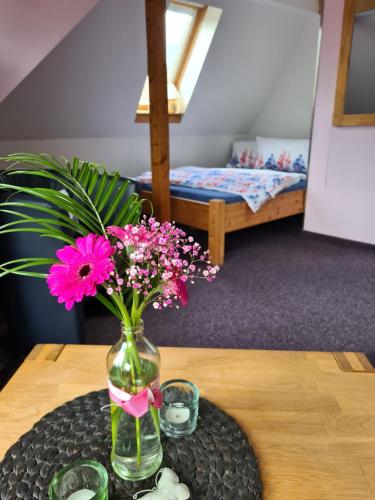 un vaso con fiori rosa seduto su un tavolo di Apartment Schneestern a Suhl