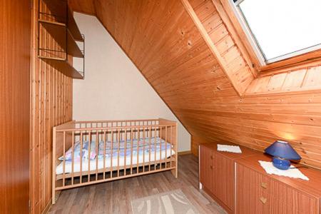 a bedroom with a bed in a wooden attic at Ferienwohnung im Haus Fooken in Stedesdorf
