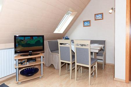 a living room with a dining table and a television at Ferienwohnung im Haus Fooken in Stedesdorf