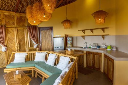a kitchen with a couch in the middle of a room at Elang Hillside Bamboo Villas in Labuan Bajo