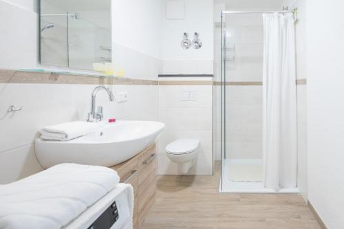 a white bathroom with a sink and a shower at Utsicht in Halebüll