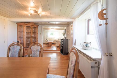a kitchen and dining room with a table and chairs at Sputnik in Nordstrand