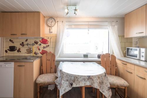 a kitchen with a table and chairs and a window at Sputnik in Nordstrand