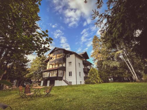 a large white house on a grassy field at Haus Partale in Oberstdorf