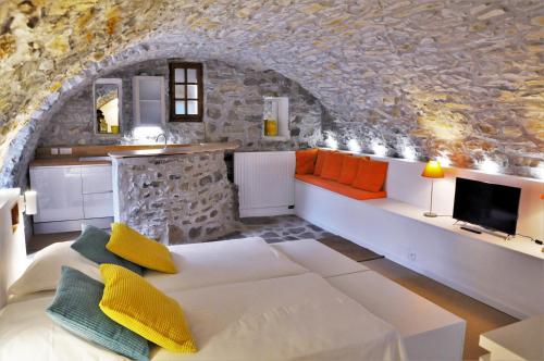a living room with a white couch and a stone wall at Un je ne sais quoi de Paradis in Les Vans