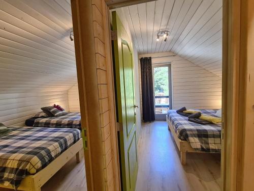 a room with two beds and a door to a bedroom at Chalet Cato in Durbuy