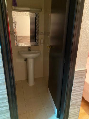 y baño con lavabo, aseo y espejo. en PENSIÓN ROSA, en Benidorm