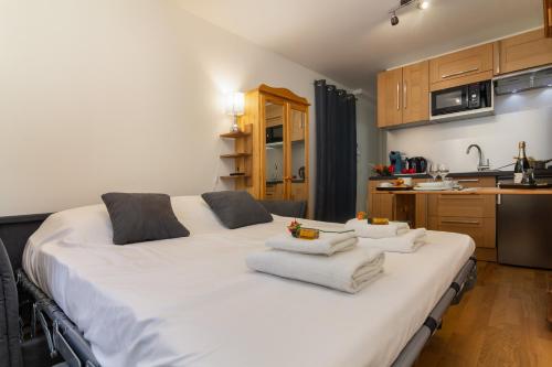 a large white bed in a kitchen with towels on it at Appartement Paccard 305 - Happy Rentals in Chamonix