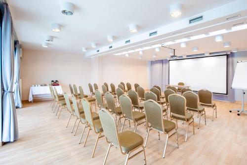 a conference room with chairs and a projection screen at Hotel Opole Centrum in Opole