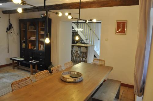 a dining room with a wooden table and chairs at Un je ne sais quoi de Paradis in Les Vans