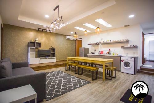 Paradise Suite at Asiacity في كوتا كينابالو: غرفة معيشة مع طاولة ومطبخ