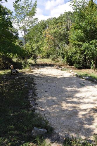a park bench sitting in the middle of a dirt road at Un je ne sais quoi de Paradis in Les Vans