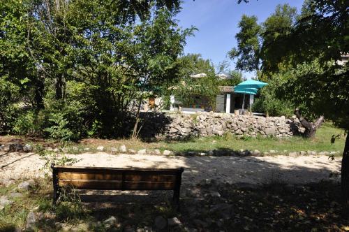 a park bench in front of a stone wall at Un je ne sais quoi de Paradis in Les Vans