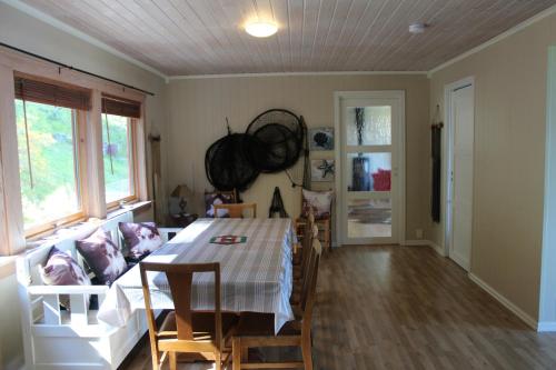 a living room with a table and a couch at Hjelvikhytta - flott beliggenhet ved sjøen in Hjelvik