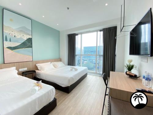 Una habitación de hotel con dos camas y un televisor de pantalla plana. en Paradise Suite at Sutera Avenue, en Kota Kinabalu