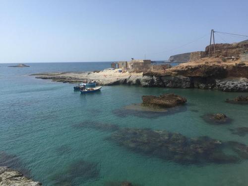 a boat in the water next to a rocky shore at Panorama Apartment Nador Jadid Klima Parking Only Family in Nador