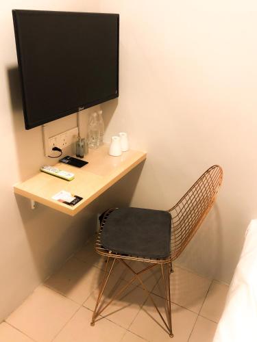 a desk with a computer monitor and a chair at HAKO XPRESS TMN SKUDAI BARU in Skudai
