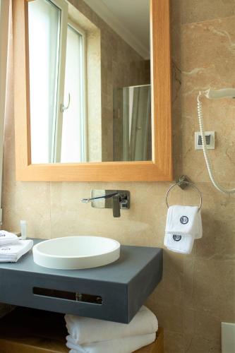 a bathroom with a sink and a mirror at Hotel Glory in Oradea