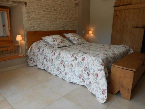 a bedroom with a bed with a floral bedspread at Les Grands Prés in Geney