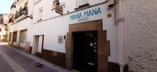 
a building that has a sign on the side of it at Mana Mana Youth Hostel in Tossa de Mar
