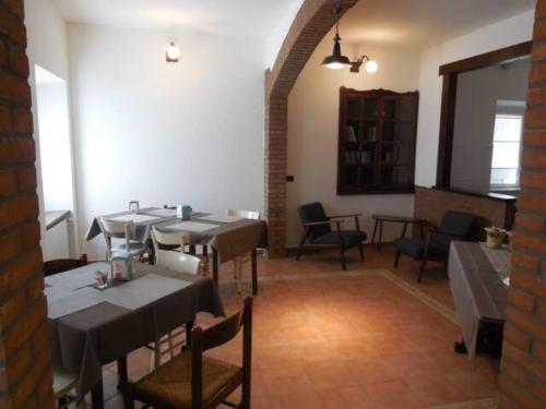 un restaurante con mesas y sillas en una habitación en Le Camere della Piazza, en Rigoso