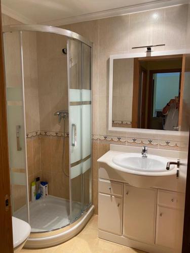 a bathroom with a shower and a sink at Piso Vista os castelos in Viveiro