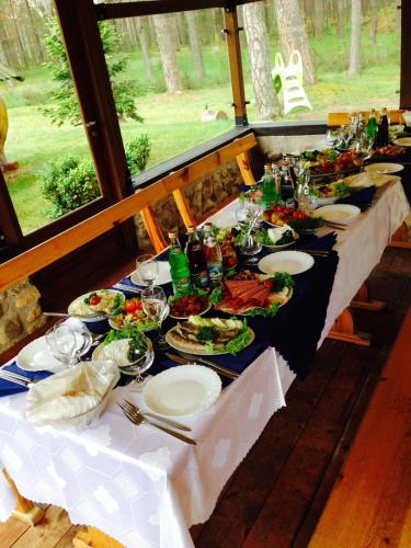 a long table with plates of food on it at El Arm El in Druskininkai