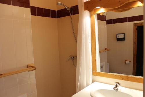 een badkamer met wastafel en douche met spiegel bij Résidence Saboia B54 Clés Blanches Courchevel in La Tania