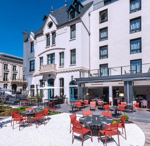 an exterior view of a hotel with tables and chairs at Radisson Blu Hotel, Rouen Centre in Rouen