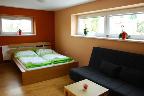 Pokój z łóżkiem, kanapą i oknami w obiekcie Vinařství Novotný w mieście Čejkovice