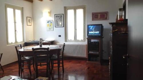a dining room with a table and a television at accogliente appartamento a Parma in Case Nuove