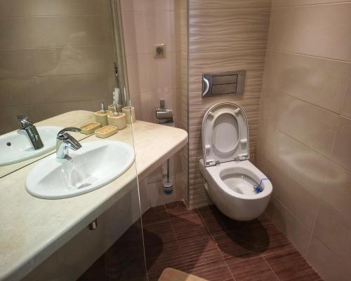 a small bathroom with a toilet and a sink at Elegantz Apartments LaMer in Varna City