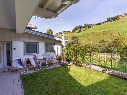 a backyard with chairs and a table and a fence at Silber Lodge im Wiesenstein in Auffach