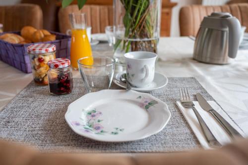 a table with a plate and a cup on a table at Bed & Breakfast 't Vèèrke in Dilsen-Stokkem